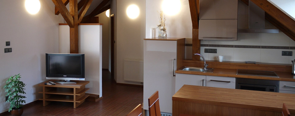 Pětilůžkový byt v patře má velký obývací pokoj s kuchyňským koutem.